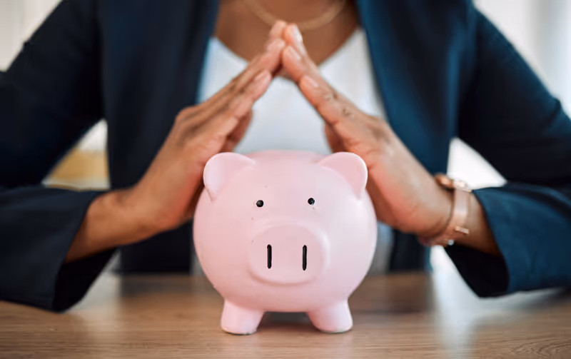Piggy Bank with a person holding their hands over it with protection